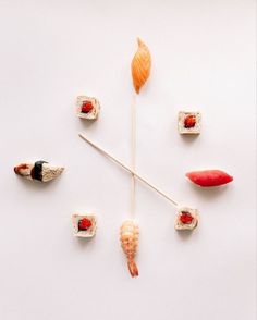 a clock made out of sushi on a white surface