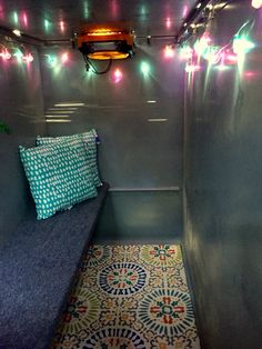 a small room with some lights on the ceiling and a bench in front of it