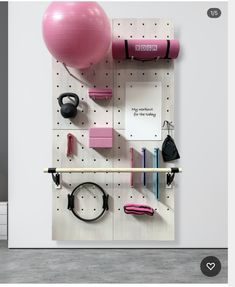 there is a pink ball, gym equipment and other items on the pegboard wall