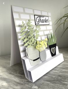 there is a card with some flowers and plants on the shelf next to each other