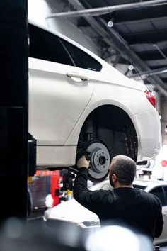 a man working on a white car in a garage