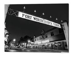 the fort worth stock yards sign is lit up at night in black and white photo