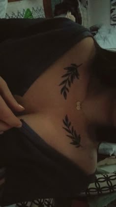 a woman with a tattoo on her stomach has leaves tattooed on her side behind her head