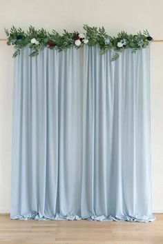 two blue drapes with flowers and greenery on them