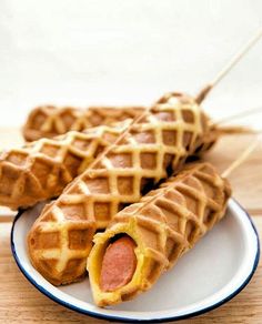 two waffles on a plate with hot dogs in them