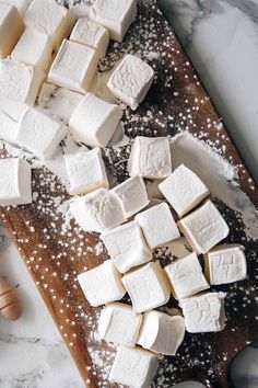 marshmallows on a cutting board with sugar sprinkled around them