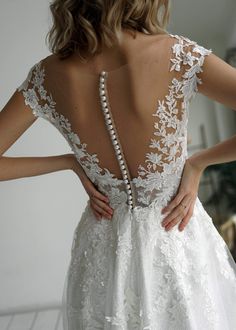 the back of a woman's wedding dress with beaded details and pearls on it