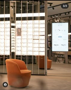 an orange chair sitting in front of a display case with glasses on it's sides