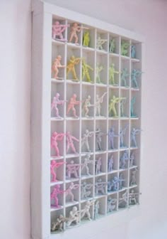 the toy soldiers are arranged in an organized shelving unit on the wall above the bed