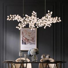 a dining room table with two chairs and a chandelier hanging from the ceiling