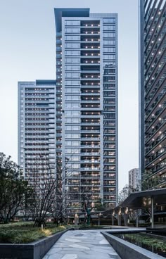 an empty walkway in front of two tall buildings