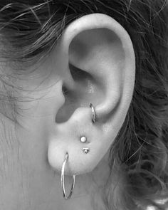 a close up of a person's ear with two piercings