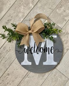 a wooden sign that says welcome with a bow on it