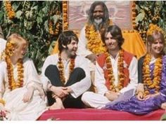 some people are dressed up and smiling for the camera while sitting on a red blanket