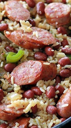 rice and beans are mixed together in a skillet with sausages, peppers, and onions