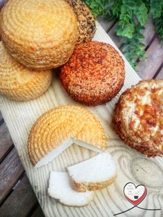 four different types of pastries on a wooden table next to some plants and leaves