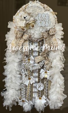 an elaborate white and gold headdress with a teddy bear on it's back