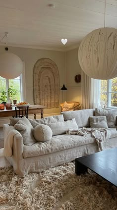 a living room filled with lots of furniture next to a large white couch and coffee table