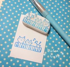 a rubber stamp with cats on it next to a pen