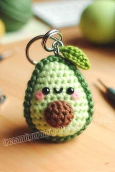 a crocheted keychain with a green and brown bird on it's face