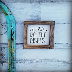 a sign that says, alexa do the dishes hanging on a white wooden wall