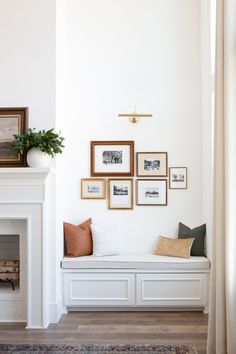 a living room filled with furniture and framed pictures on the wall above a fire place