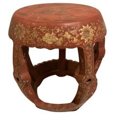 an old red stool with gold designs on it