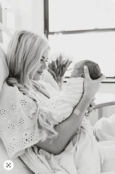 a black and white photo of a woman holding a baby