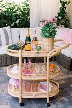 a wicker bar cart with bottles and glasses on it