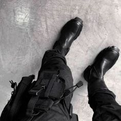 black and white photograph of person with backpack laying on concrete floor, looking down at camera