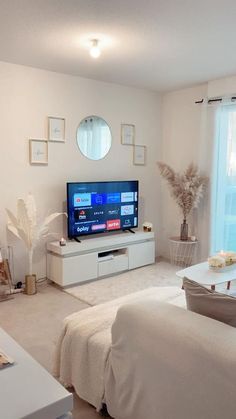 a living room filled with furniture and a flat screen tv on top of a entertainment center