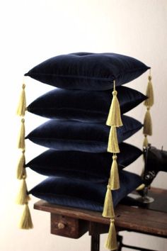 four pillows stacked on top of each other with tassels