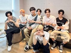 group of young men sitting next to each other on a couch in an office building