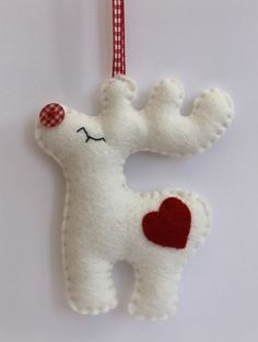 a stuffed animal ornament hanging on a red and white checkered ribbon with a heart