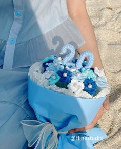 a woman is holding a blue and white bouquet with the number twenty two on it