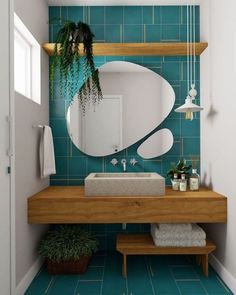 a bathroom with blue tile and wooden shelfs on the wall next to a sink