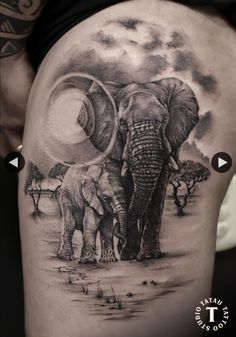 an elephant and its baby are depicted in this tattoo design on the back of a woman's thigh