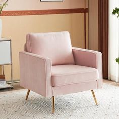 a pink chair sitting on top of a white rug next to a vase filled with flowers