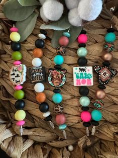 a basket filled with lots of different colored beads and charms next to a stuffed animal