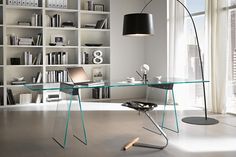 a glass desk in front of a book shelf