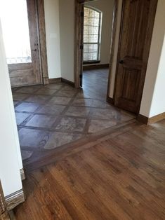 an empty room with wooden doors and hard wood flooring on the side of it