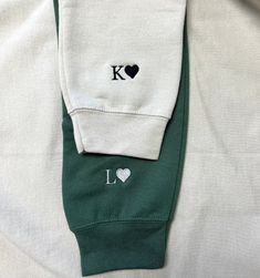 a white and green sweatshirt with the letter k on it's left chest pocket