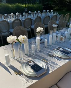 the table is set with silverware and white flowers