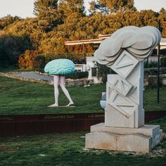 a large statue with a brain on it's head in the middle of a park