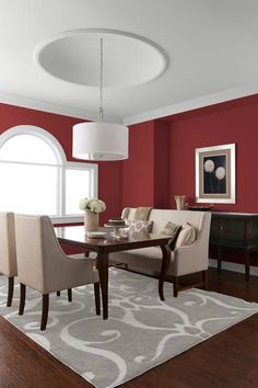 a dining room with red walls and white trim on the windowsill is pictured in this image