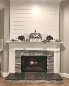 the fireplace is decorated with pumpkins and greenery on it's mantel