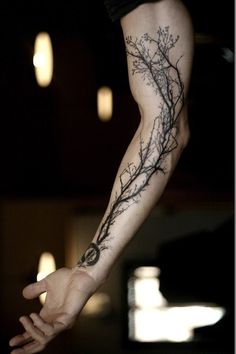 a person with a tree branch tattoo on their arm