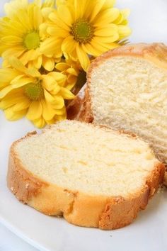 two slices of bread on a white plate next to yellow flowers