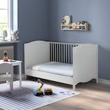 a child's room with blue walls and white furniture