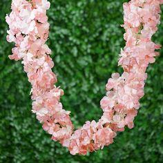 pink flowers are arranged in the shape of a heart on top of a green background